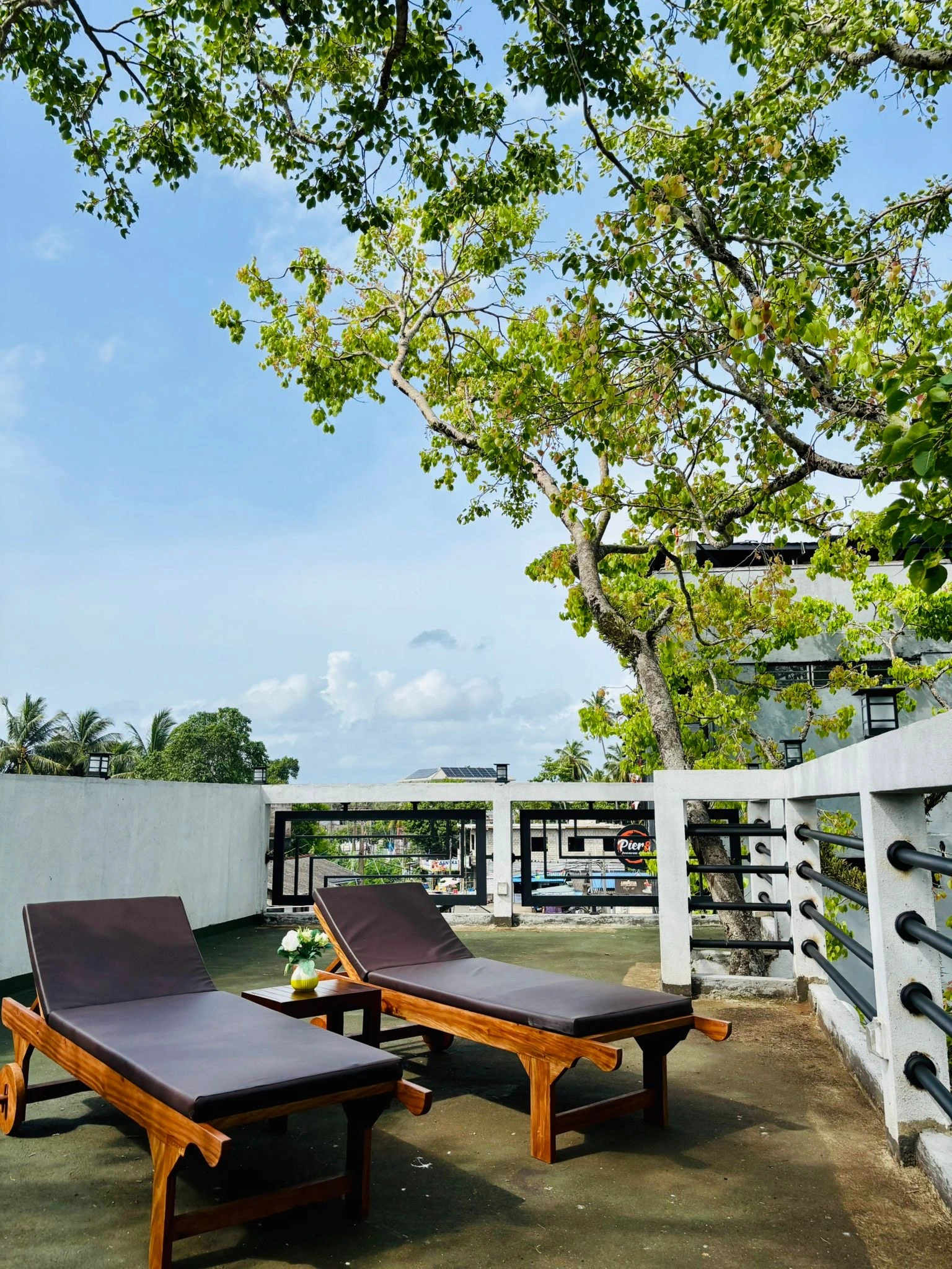 Balcony with wooden sun loungers and tree view